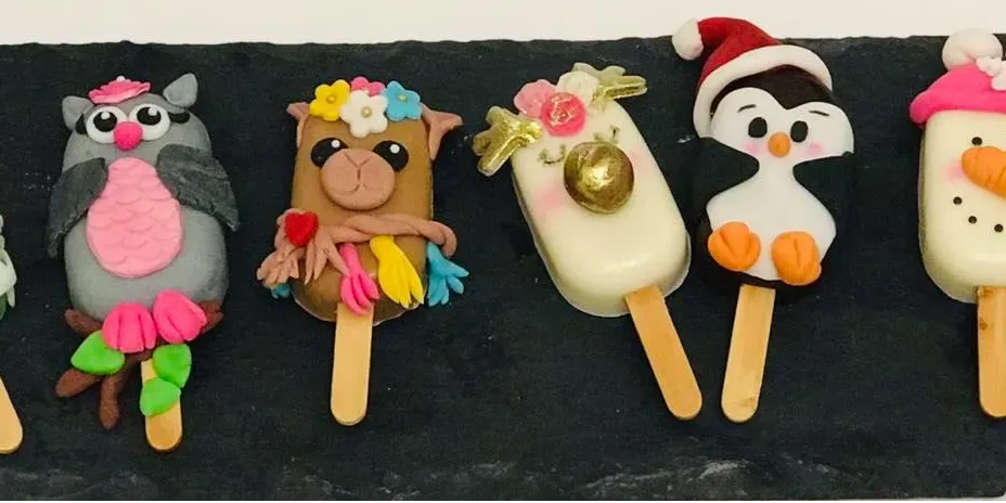 Variedad de paletas de chocolate con diseños creativos y coloridos.