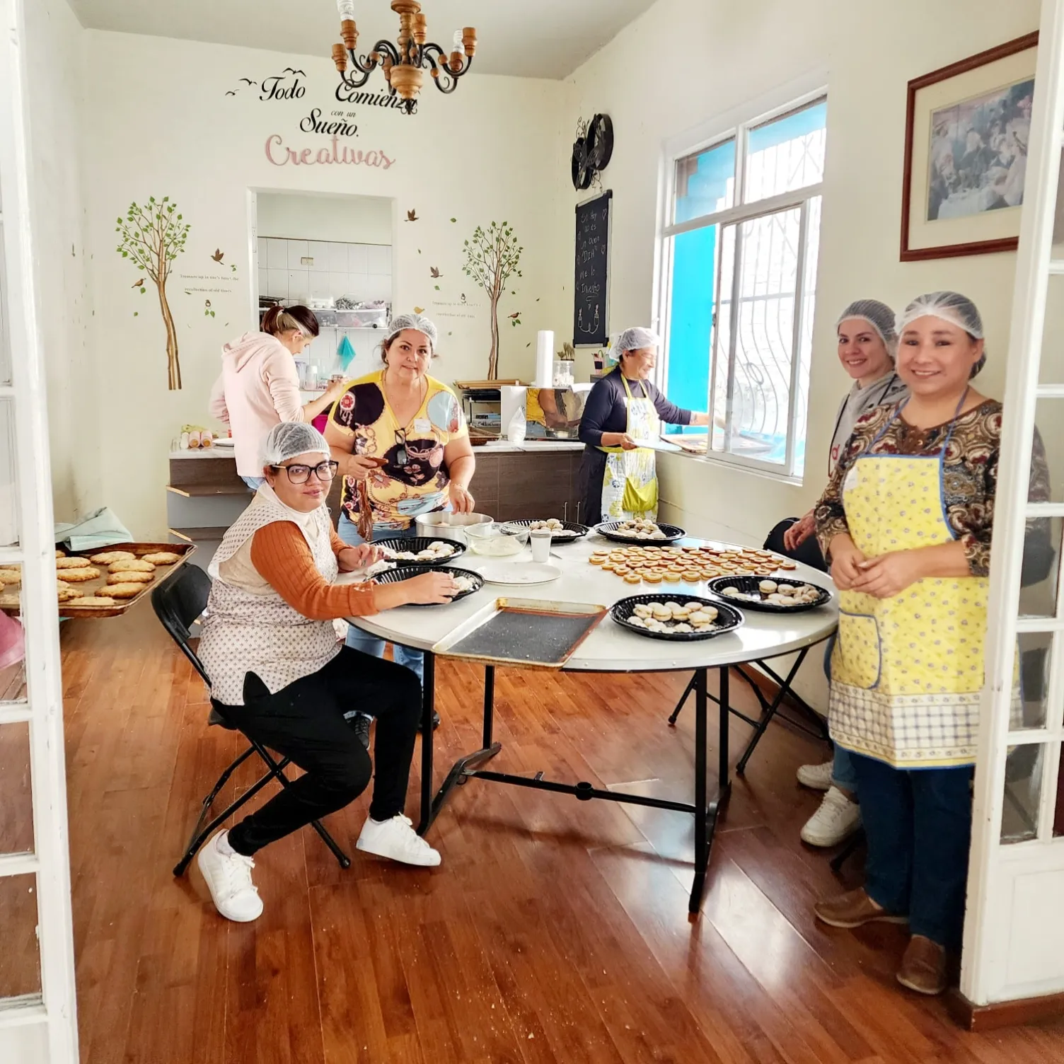 Mujeres entusiastas colaboran en la creación de deliciosas galletas gourmet en una clase vibrante.