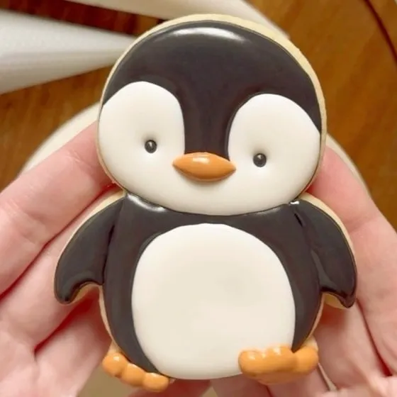 Pingüino de galleta decorado con glasé, una manualidad tierna.